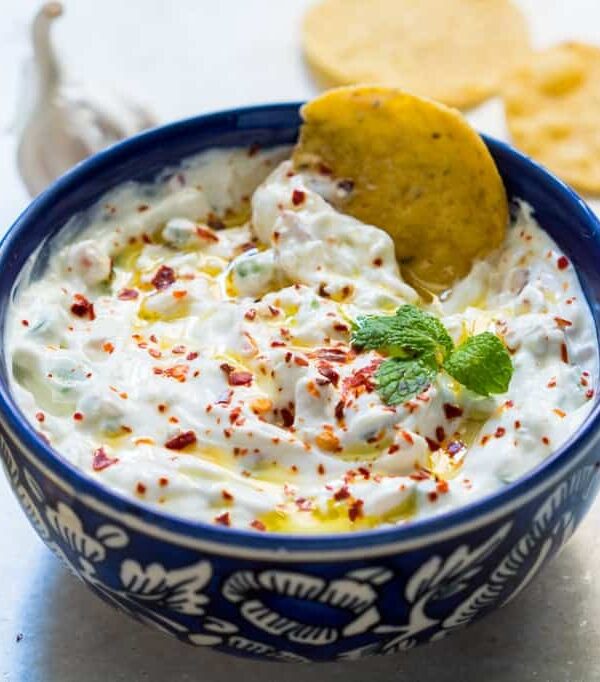A close up of A picture of Garlicky yogurt party dip served in a blue bowl with chips
