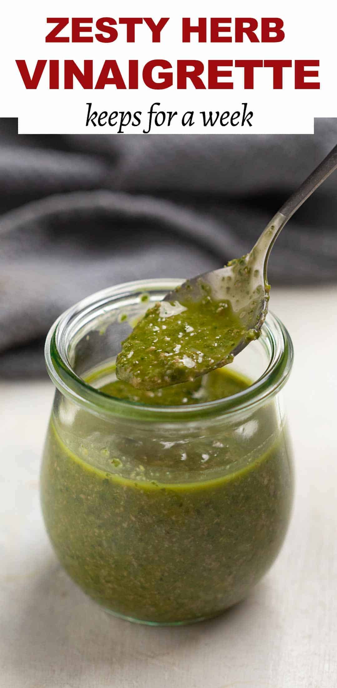 Herb vinaigrette in a jar with a spoon being taken out