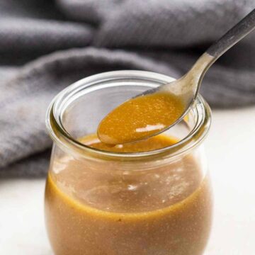 Honey mustard in a jar with a spoon being taken out