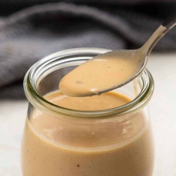 Thai Peanut sauce in a jar with a spoon being taken out