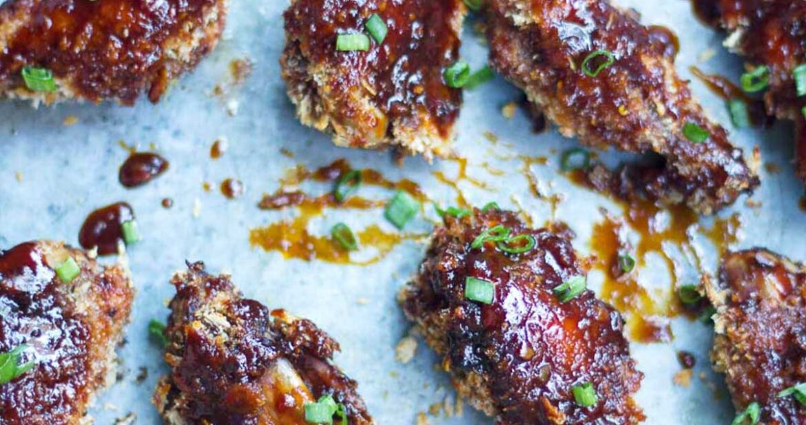 Baked Sticky Chicken Wings lined up on a tray.