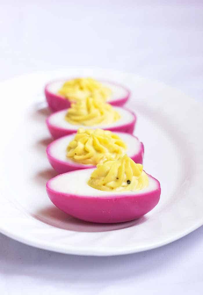 pink dyed eggs placed on a white plate