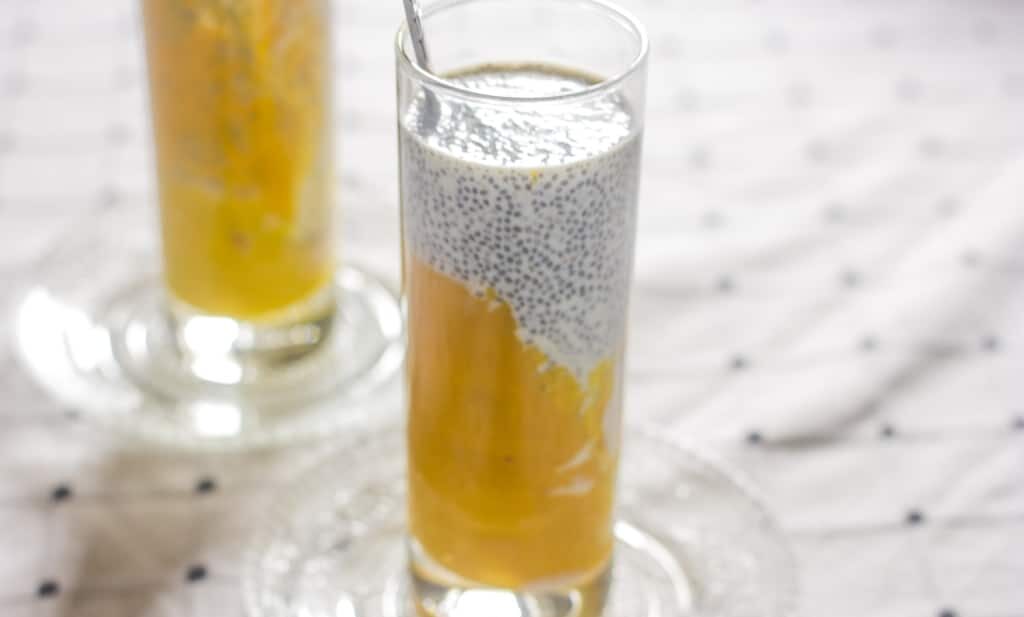 The Mango Chia seed breakfast drink served in a glass with a spoon.