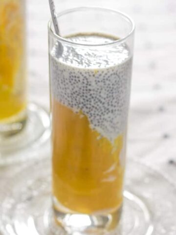 The Mango Chia seed breakfast drink served in a glass with a spoon.