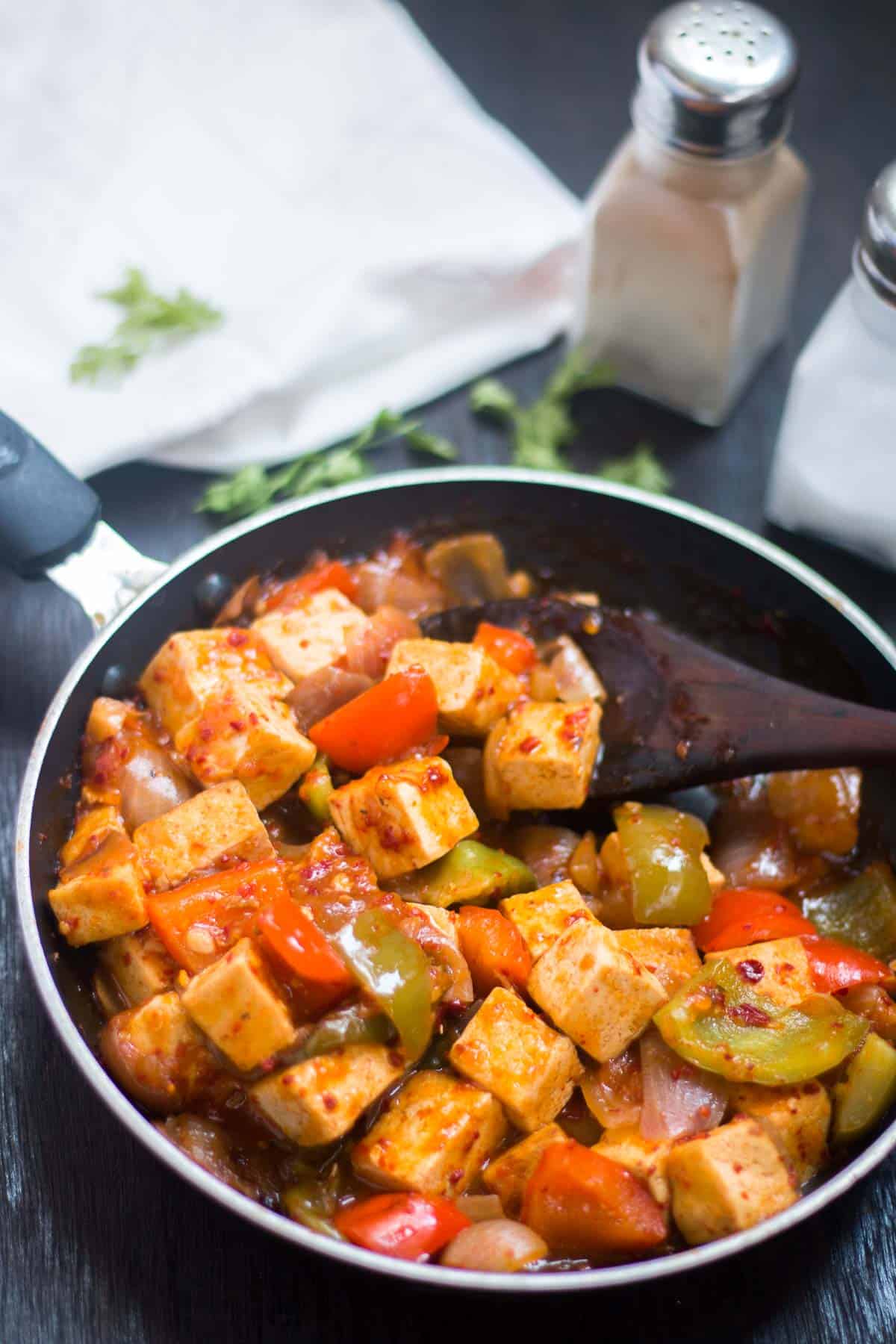 Sweet Chili Tofu Stir Fry being prepared in a black pan.