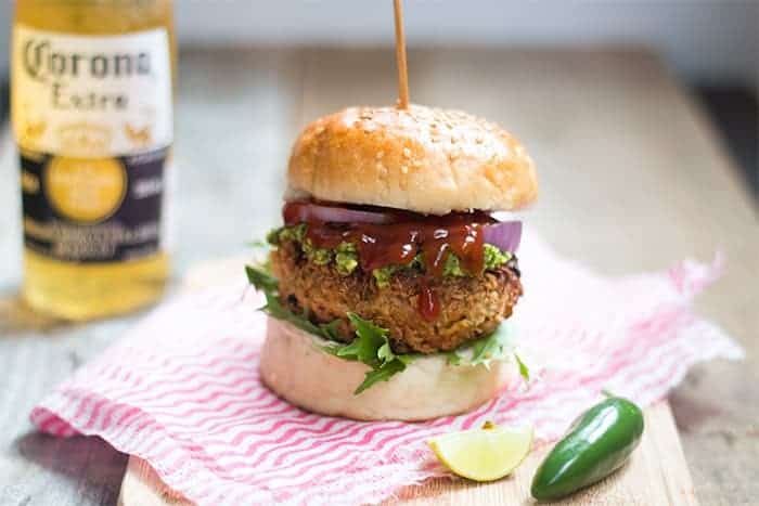 The Fully Loaded Veggie Burger with Avocado Mint Chutney served on a wooden board.