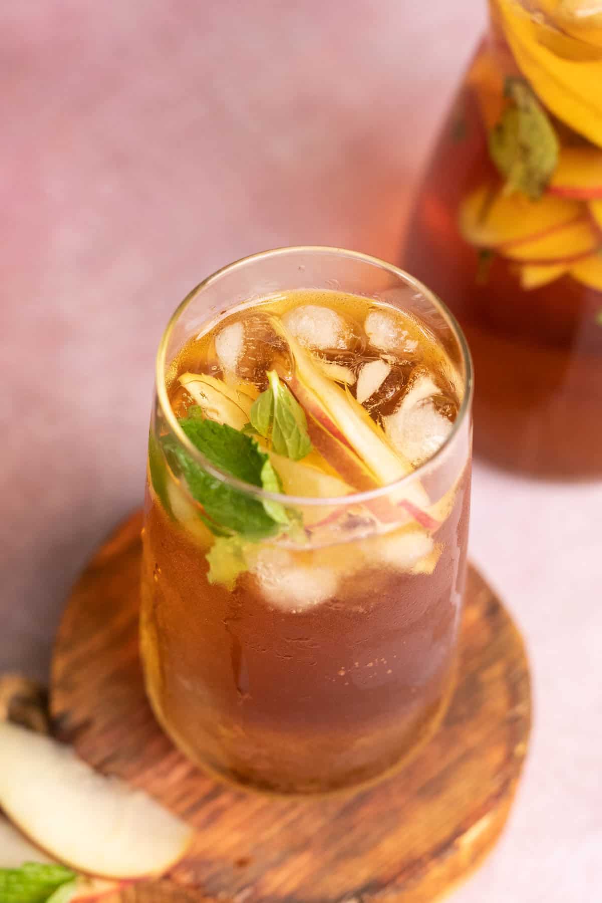 A glass of Virgin Apple Iced Tea with slices of apple inside