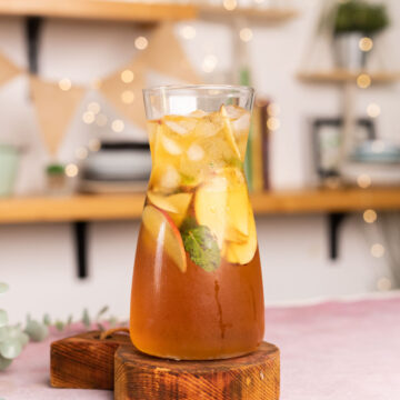 A pitcher of Virgin Apple Iced Tea with slices of apple inside