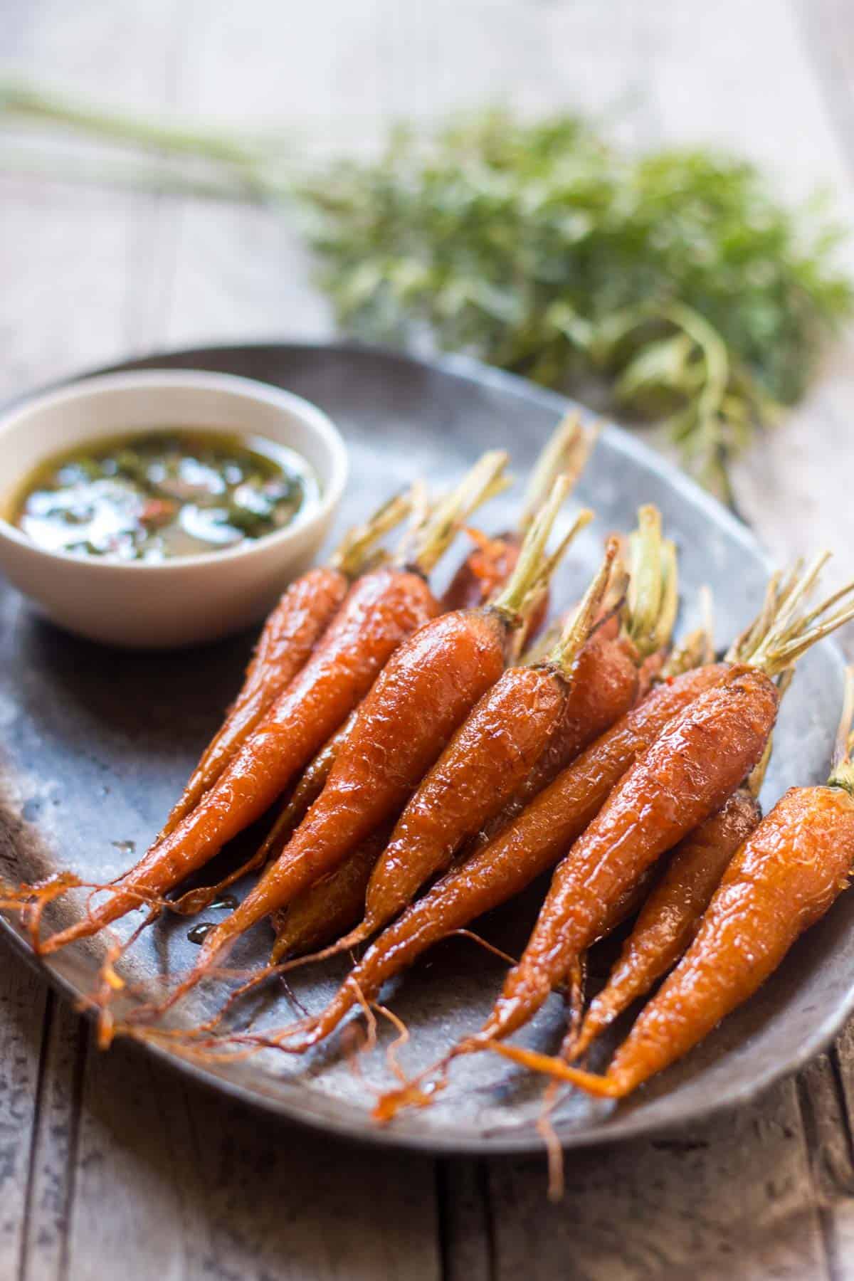 Honey Ginger Roasted Carrots plated with Carrot Greens Chimichurri.