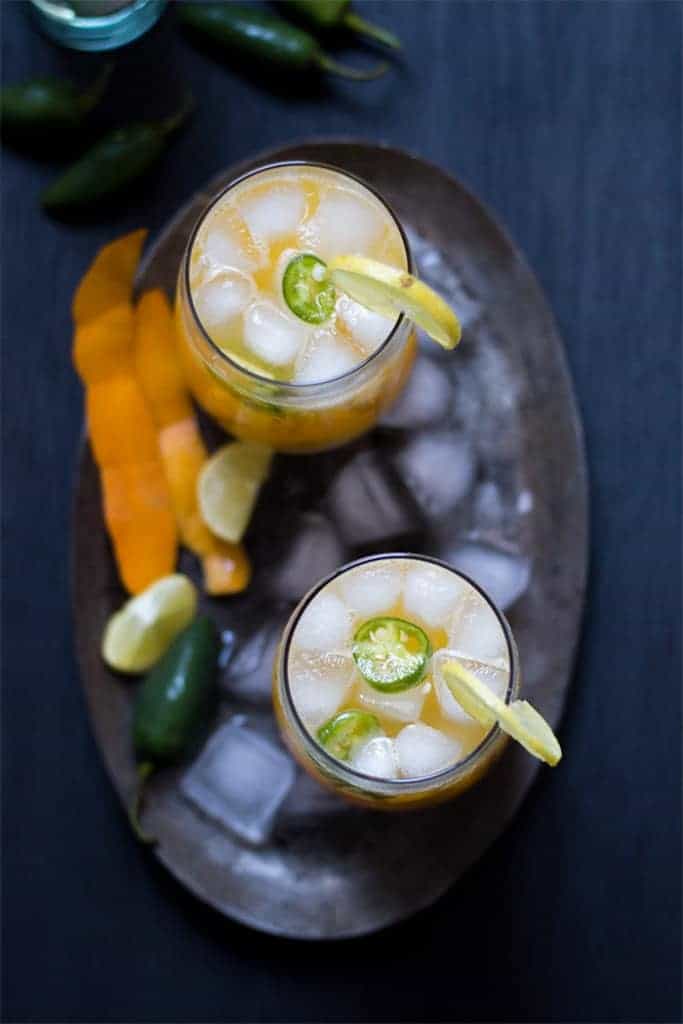 tall mango jalapeno fizzy cocktail served with ice and slices of lemon