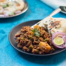 The mutton keema plated with naan, chopped onions and lime.