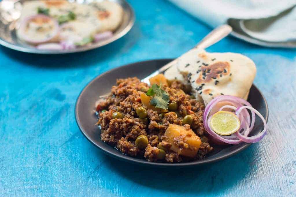 mutton keema plated with naan, chopped onion and lime