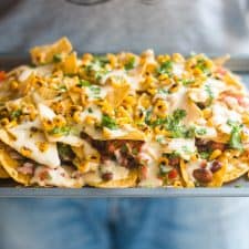 The loaded nachos being served in a tray.