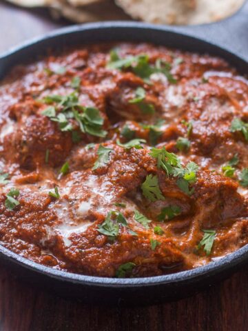 The healthier version of Chicken Tikka Masala garnished with coriander in a pan.