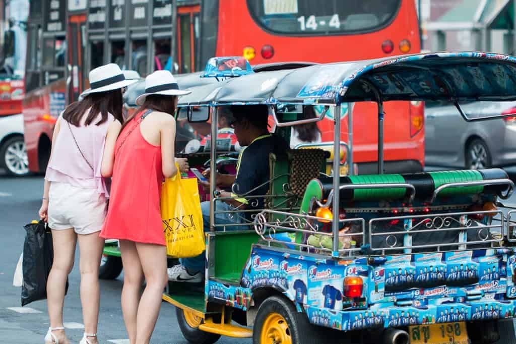 A picture of two Bangkok locals grabbing a local transport