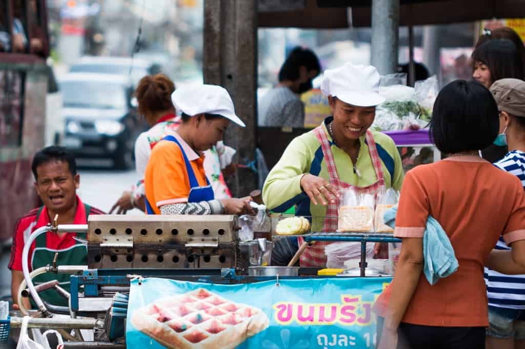 Local chefs happily engaging with customers while selling street food