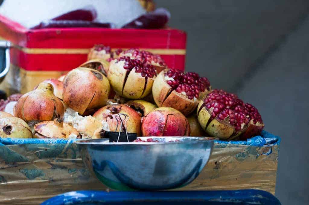 An image of cut pomegranates on a street side cart in Bangkok