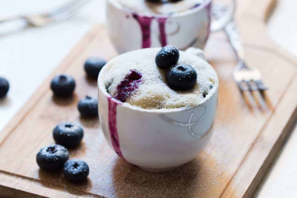 blueberry oozing out from an eggless blueberry microwave mug cake