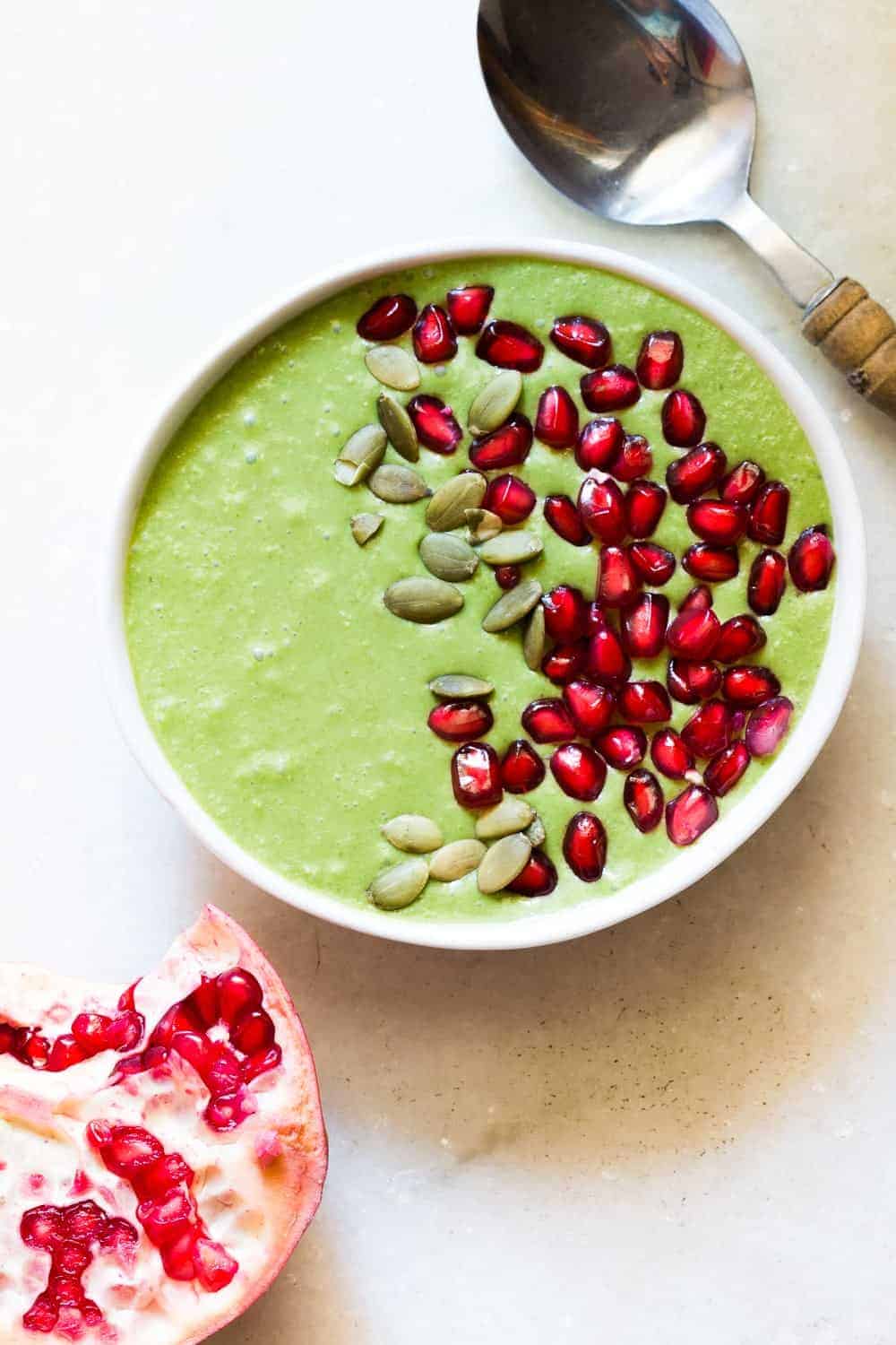 The smoothie bowl topped with pomegranate and pumpkin seeds.