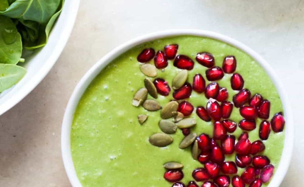 The smoothie bowl topped with pomegranate and pumpkin seeds.