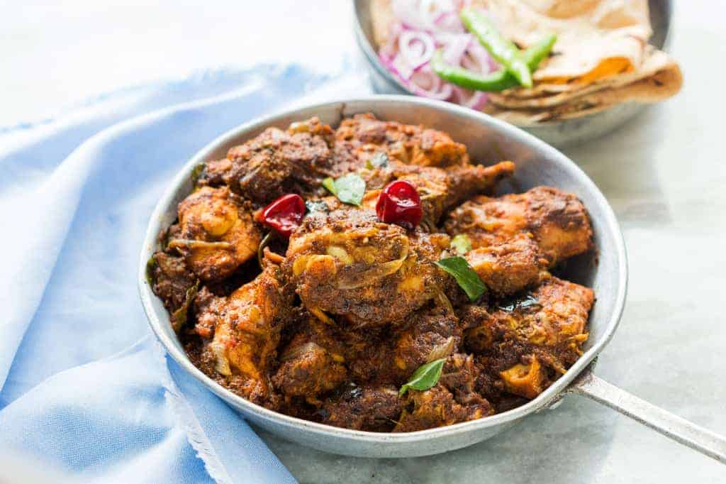 a bowl full of spicy chettinad chicken fry/roast