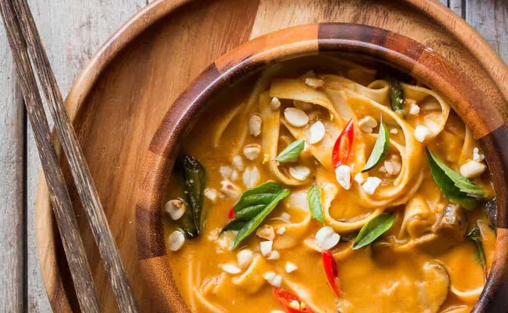 Creamy, comforting spicy thai curry pumpkin noodle soup served in a bowl.