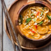 Creamy, comforting spicy thai curry pumpkin noodle soup served in a bowl.