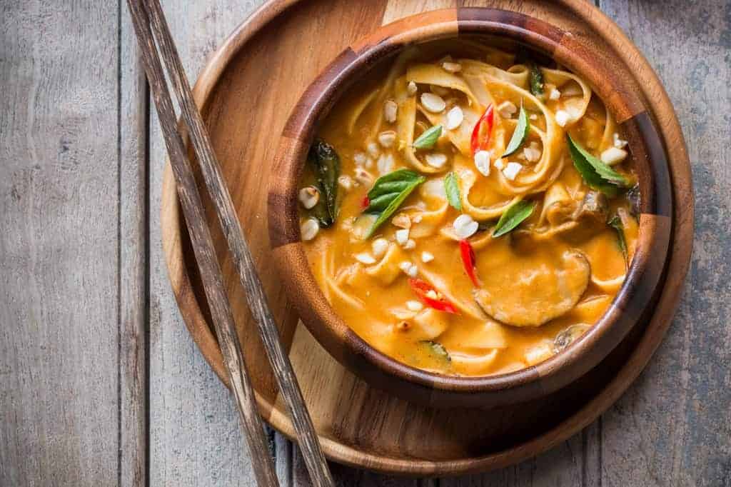 Creamy, comforting spicy thai curry pumpkin noodle soup gets ready in 20 minutes and the recipe takes you back to Thailand!