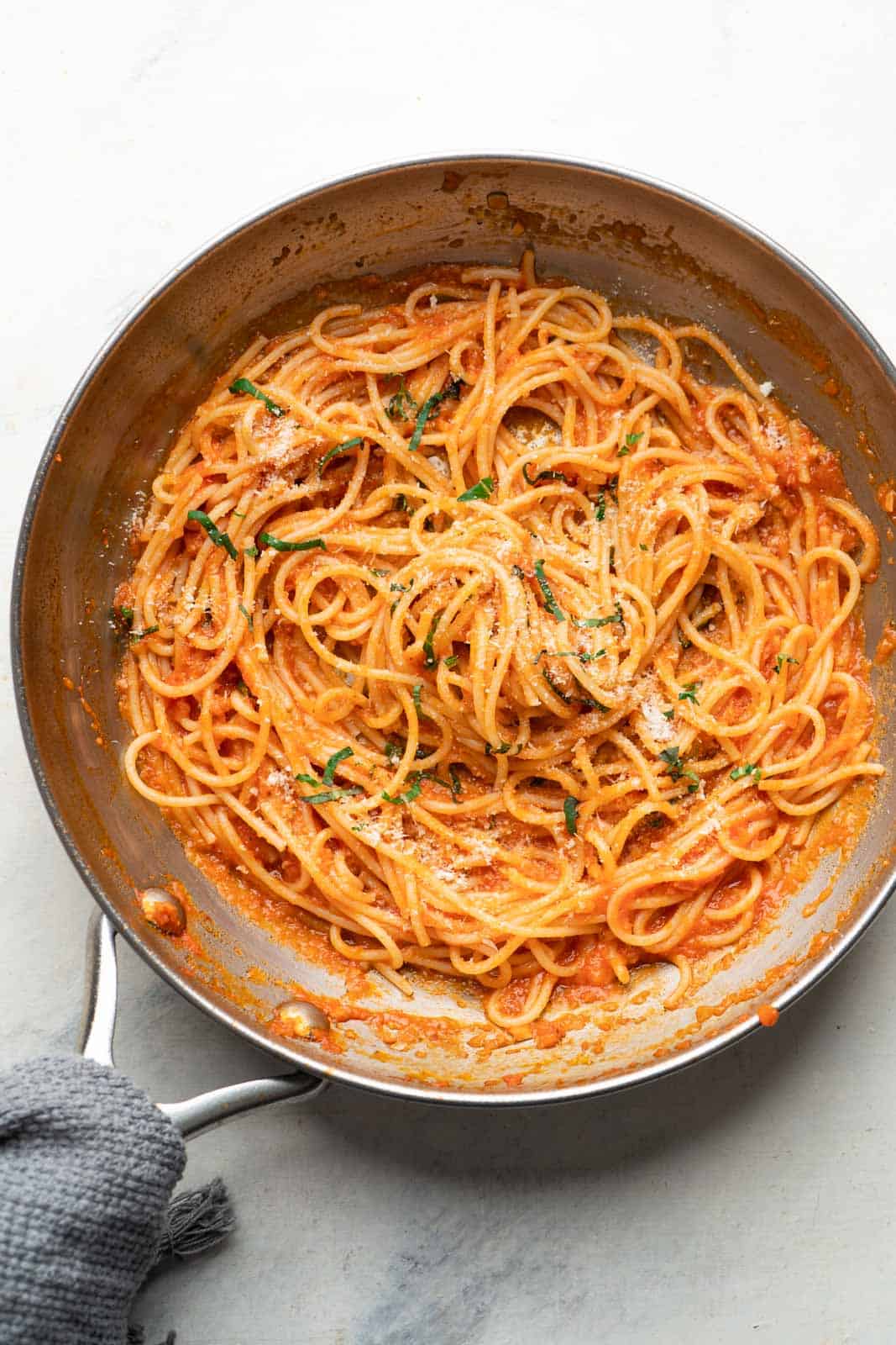 Spaghetti tossed in pasta sauce in a skillet