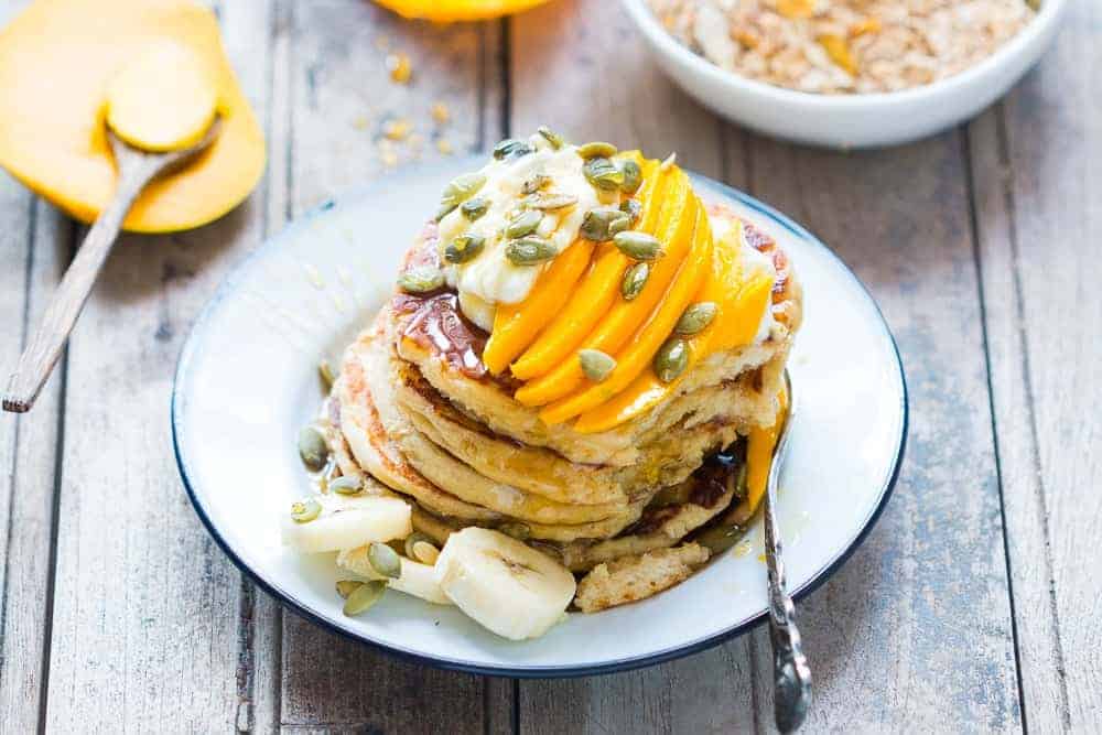 Get the recipe for the fluffiest gluten free oatmeal cottage cheese pancakes and you won't be able to tell that they are also eggless! Topped with mango yogurt and mixed nuts.