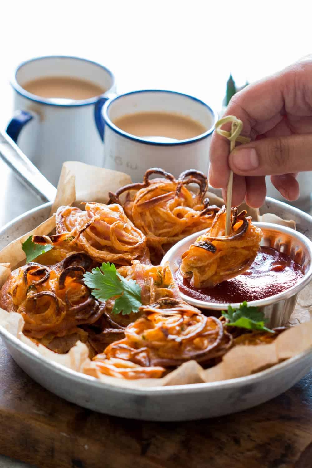 Indians love their pakodas and bhajiyas (fritters) and now there's a guilt-free way to enjoy them with a cup of masala chai. Nobody's ever going to believe these onion pakodas are baked, not fried! Can be made with potato, corn, capsicum and paneer too!