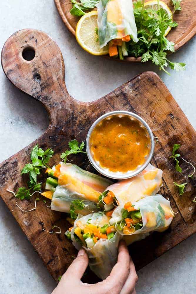 These mango bell pepper rice paper rolls are the perfect summer food! They are stuffed with lots of amazing veggies and come with an insanely delicious mango cilantro dipping sauce! These are naturally gluten free, vegan and low carb!