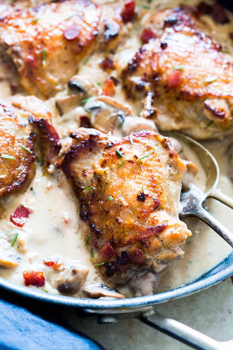 These creamy bacon rosemary mushroom chicken thighs are going to be your favorite weeknight comfort food. Chicken thighs are simmered in a lightened up alfredo like bacon sauce with mushrooms and rosemary. Serve it with pasta, or if you are looking for a low carb version, just add some steamed broccoli on the side.