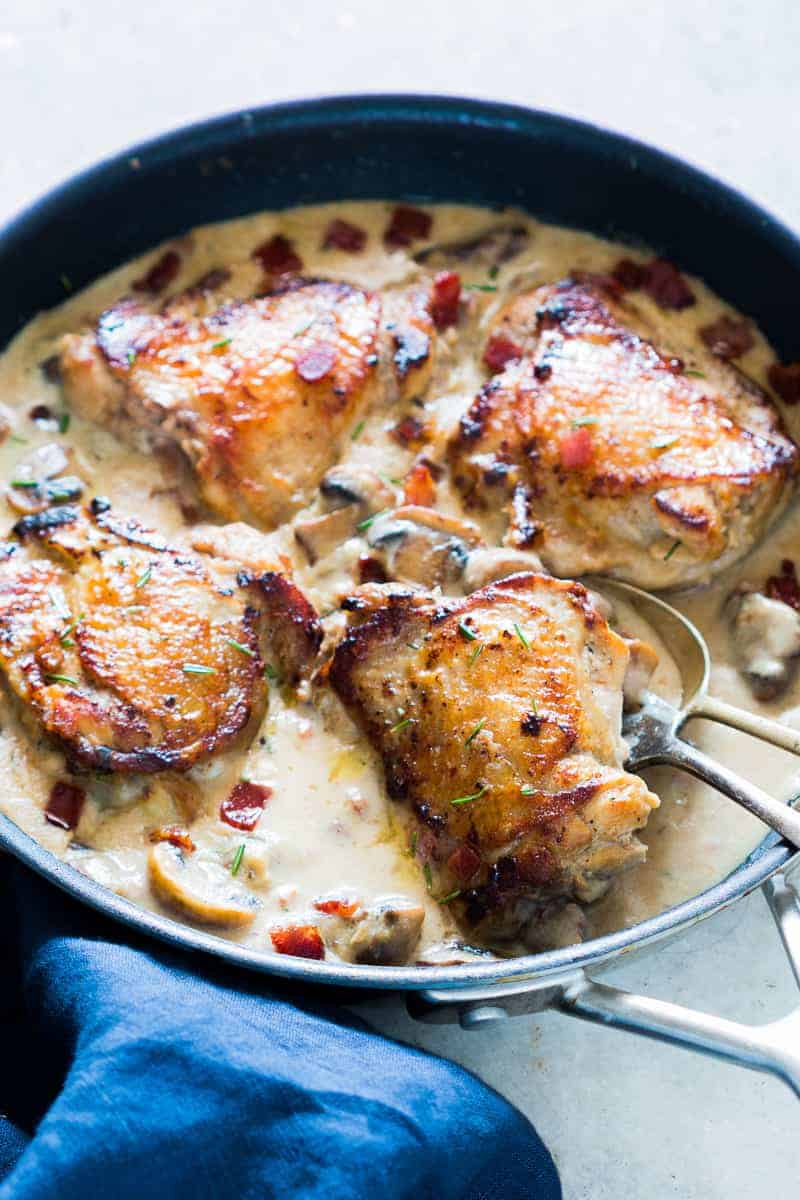 These creamy bacon rosemary mushroom chicken thighs are going to be your favorite weeknight comfort food. Chicken thighs are simmered in a lightened up alfredo like bacon sauce with mushrooms and rosemary. Serve it with pasta, or if you are looking for a low carb version, just add some steamed broccoli on the side. 