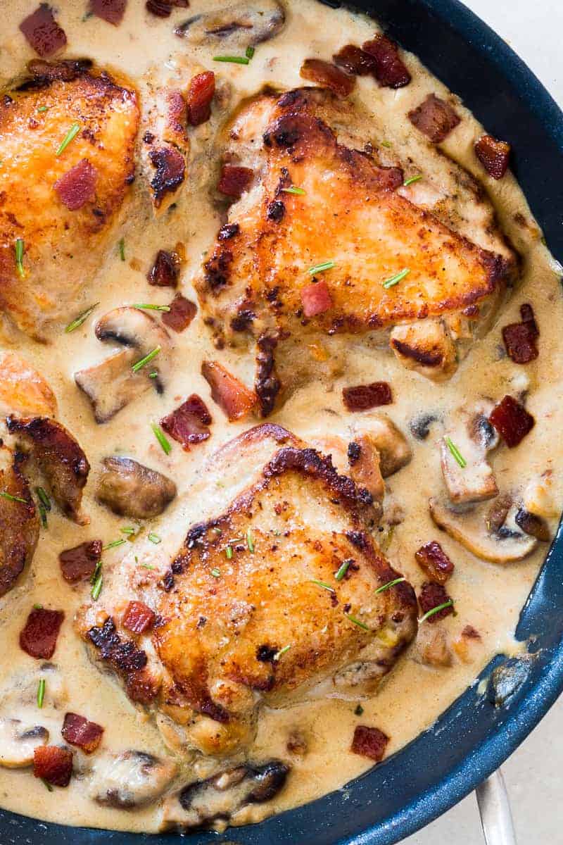 These creamy bacon rosemary mushroom chicken thighs are going to be your favorite weeknight comfort food. Chicken thighs are simmered in a lightened up alfredo like bacon sauce with mushrooms and rosemary. Serve it with pasta, or if you are looking for a low carb version, just add some steamed broccoli on the side. 
