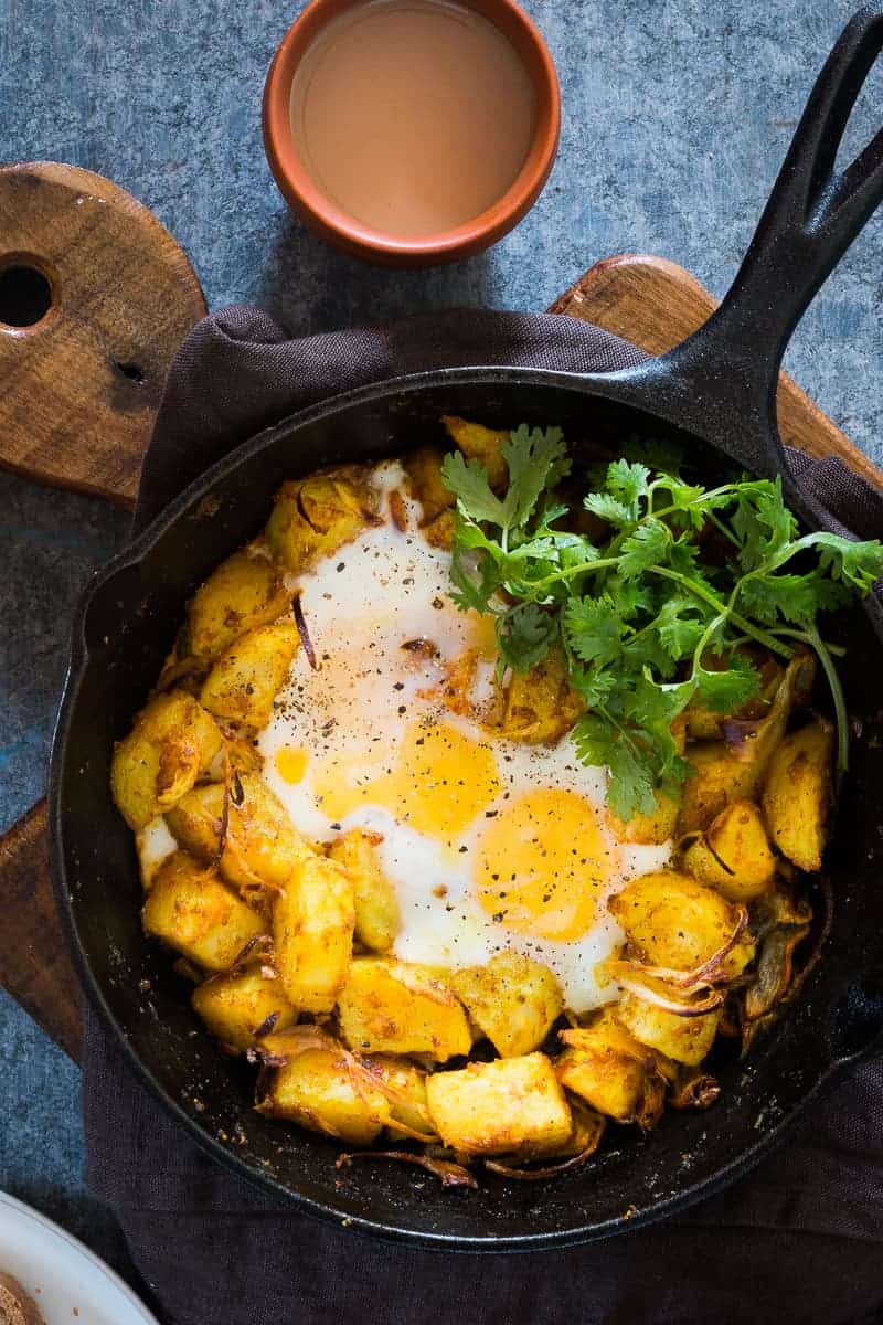 Spiced Indian Potatoes and eggs are cooked in a skillet for a hearty and easy holiday morning breakfast recipe. Perfect for a crowd, kid friendly and gluten free.