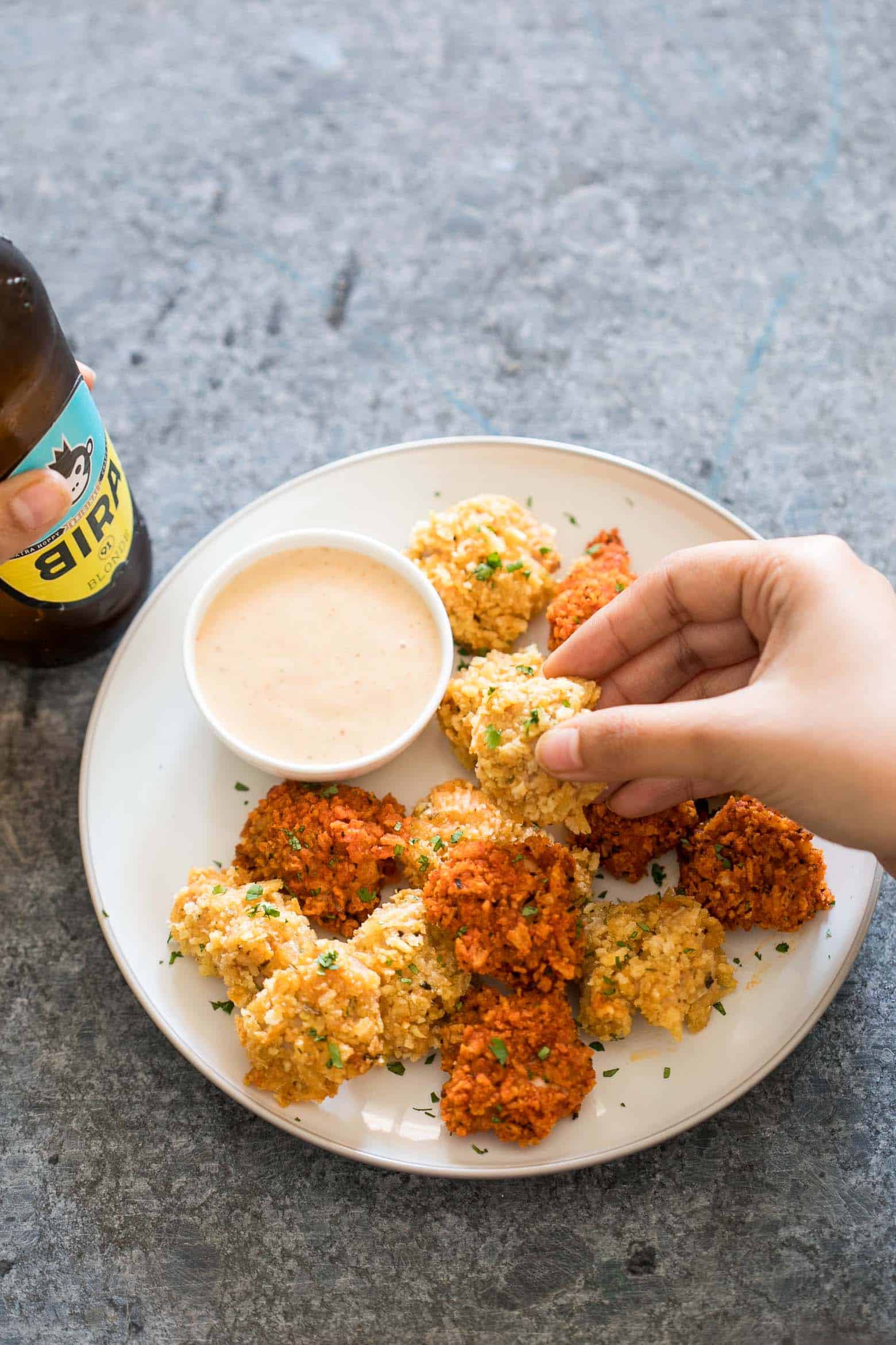 The easiest recipe for baked popcorn chicken that can be made two ways - spicy and non spicy! Tastes KFC style, but gluten free and guilt free for the perfect party appetizer. 