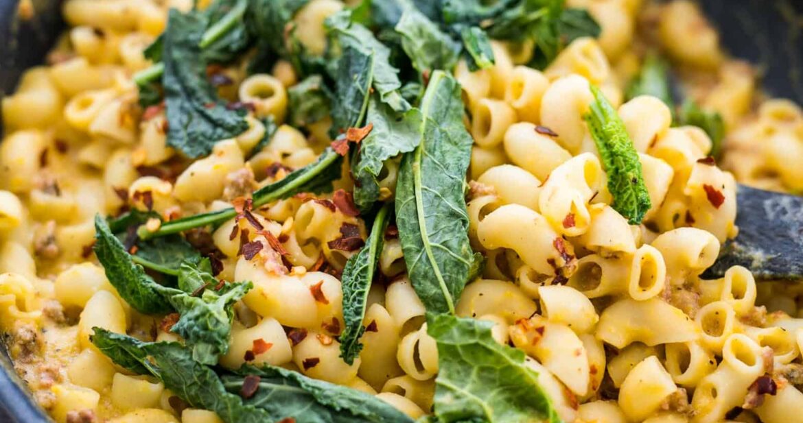 Creamy Pumpkin Sausage Mac and Cheese garnished with kale.