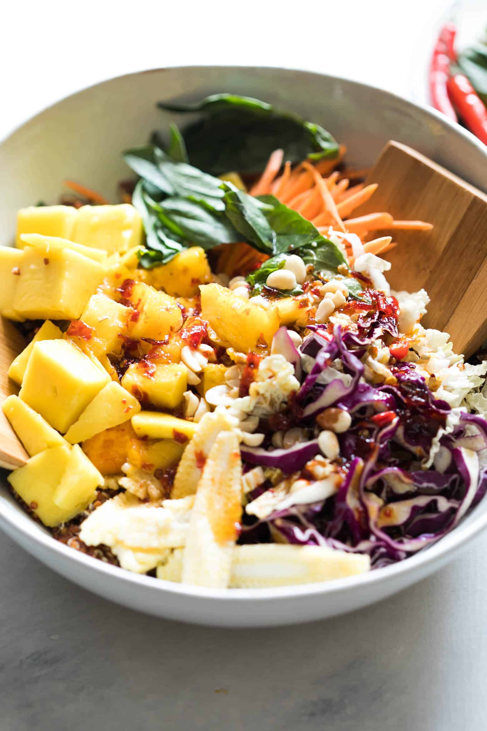 Super delicious Thai Peanut Mango Quinoa Salad which you can make ahead for potlucks and barbecues and also happens to be gluten free and vegan! Comes with a finger licking sweet and spicy sambal dressing that's different from the regular peanut dressing.