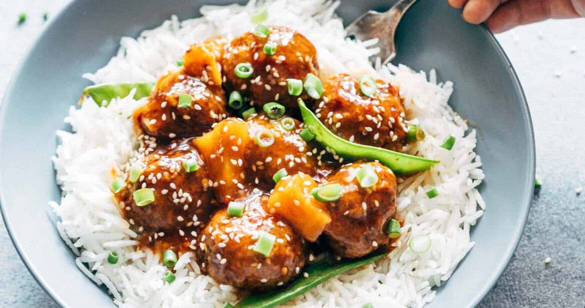 Asian inspired slow cooker teriyaki meatballs with pineapple served with steamed rice in a bowl.
