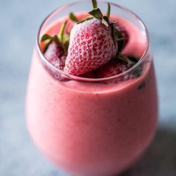 Strawberry Greek Yogurt smoothie blended till creamy and served in a glass.