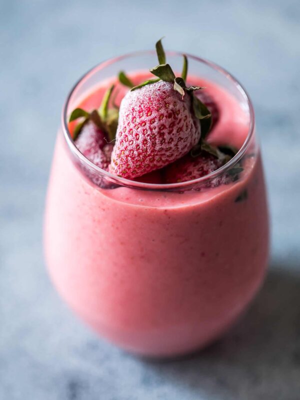 Strawberry Greek Yogurt smoothie blended till creamy and served in a glass.