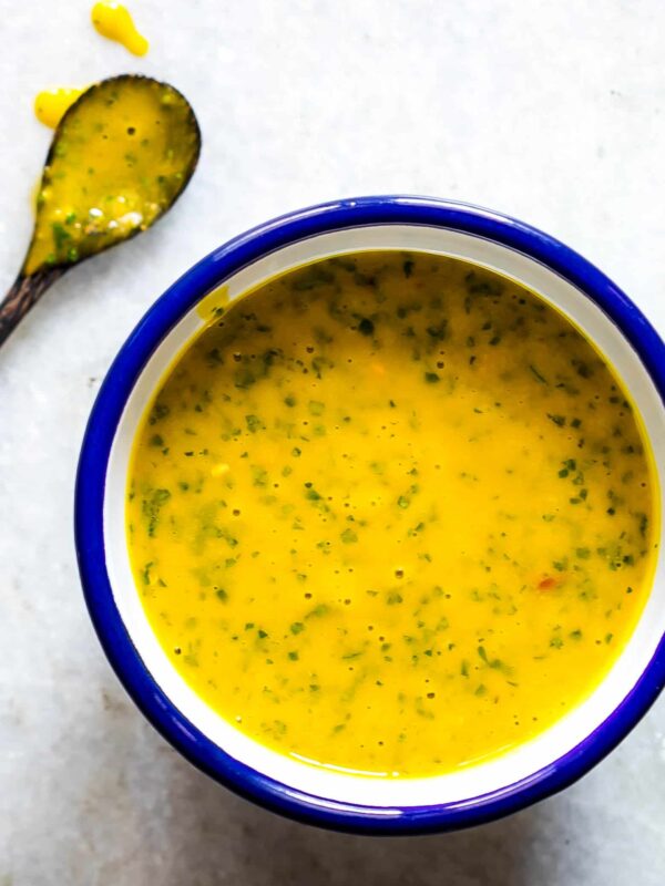 A creamy and smooth Mango Cilantro Salad Dressing in a blue and white bowl.