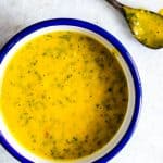 A creamy and smooth Mango Cilantro Salad Dressing in a blue and white bowl.