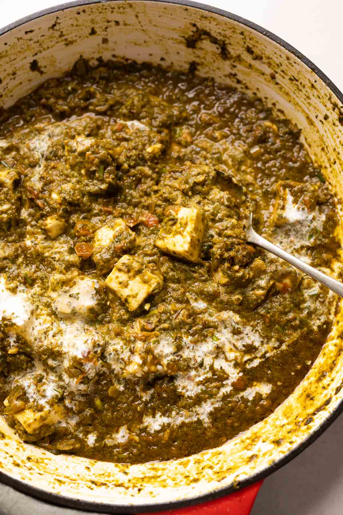 Picture of saag paneer in the pan that it was cooked in with a spoon