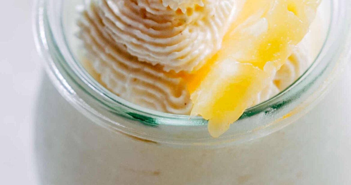 Eggless Pineapple Mousse garnished with mint and a slice of pineapple and served in a mini jar.