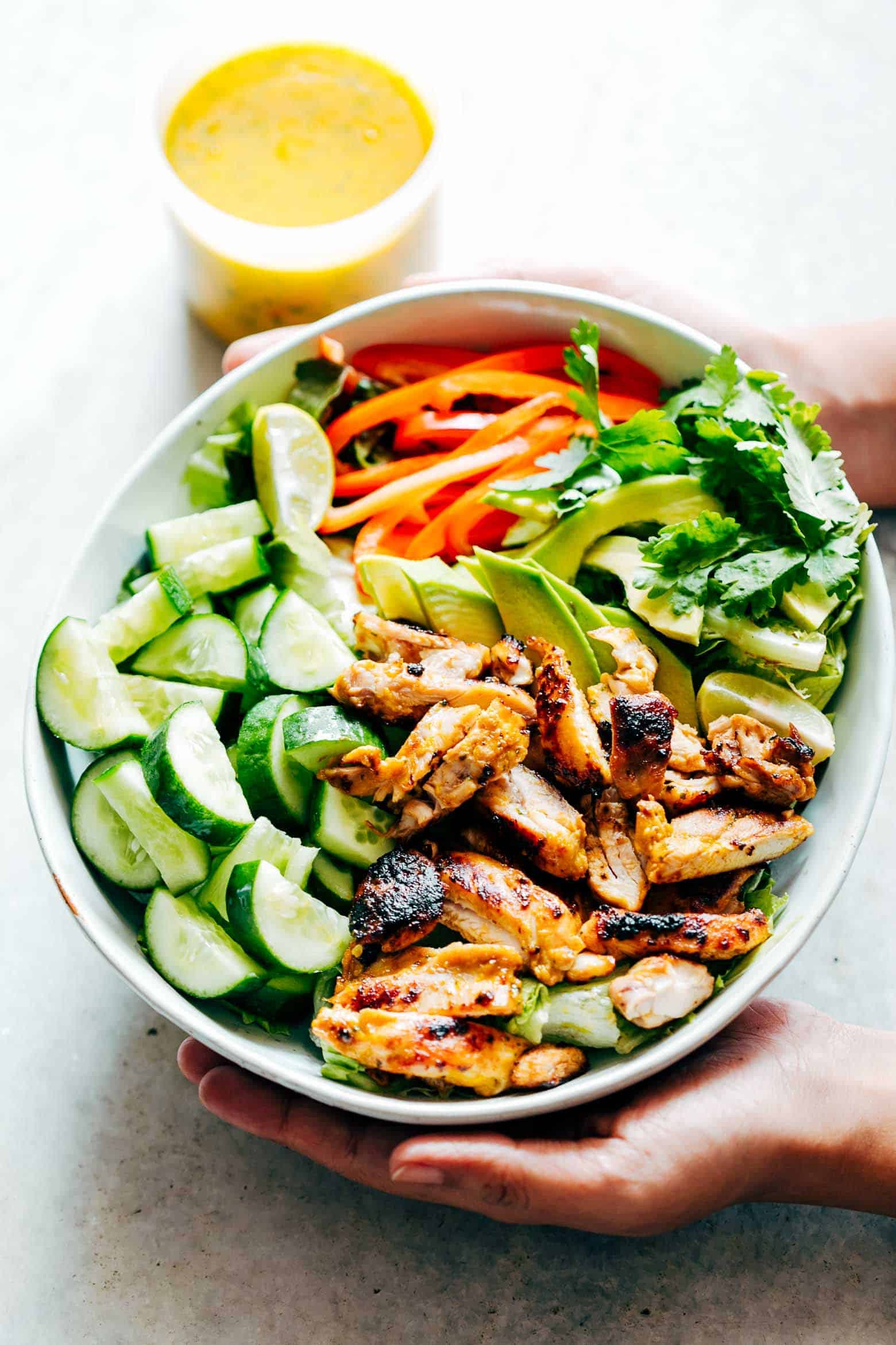 Grilled Chicken Mango Salad with Mango Cilantro Dressing is loaded with cucumbers, peppers, avocado and has a crazy good dressing that doubles up as a marinade! Uses barbecued and grilled chicken and an easy dressing. Gluten Free, Paleo, Dairy Free, Healthy. Best summer salad ever!