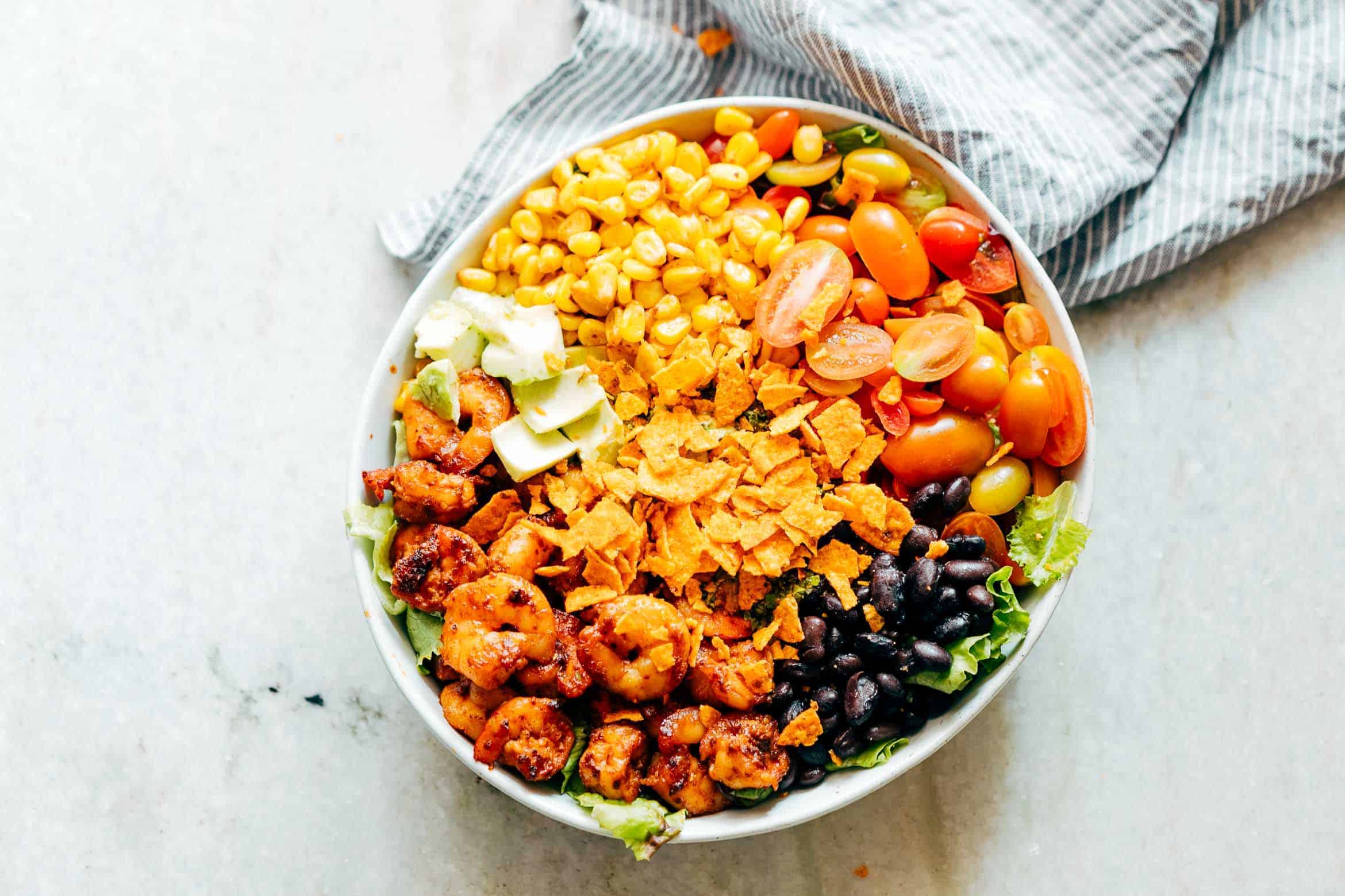 Mexican Prawn Avocado Taco Salad is a delicious, hearty salad that has all the flavours of your favourite mexican taco, but healthier. Loaded with lettuce, black beans, avocado, cherry tomatoes, corn and a delicious cilantro lime dressing, it's perfect when you want salad for dinner.