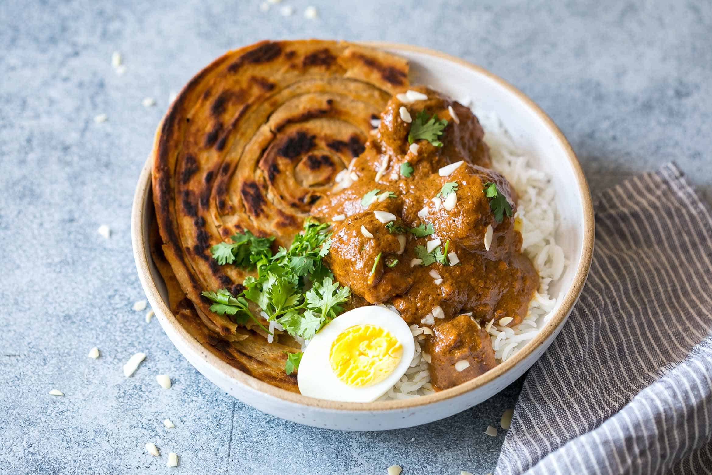 Mughlai Chicken is a restaurant style, north Indian recipe with a creamy, dark brown onion gravy that will have you licking the plate! Serve it with parathas, biryani or jeera rice, and feel free to substitute paneer if you are vegetarian.
