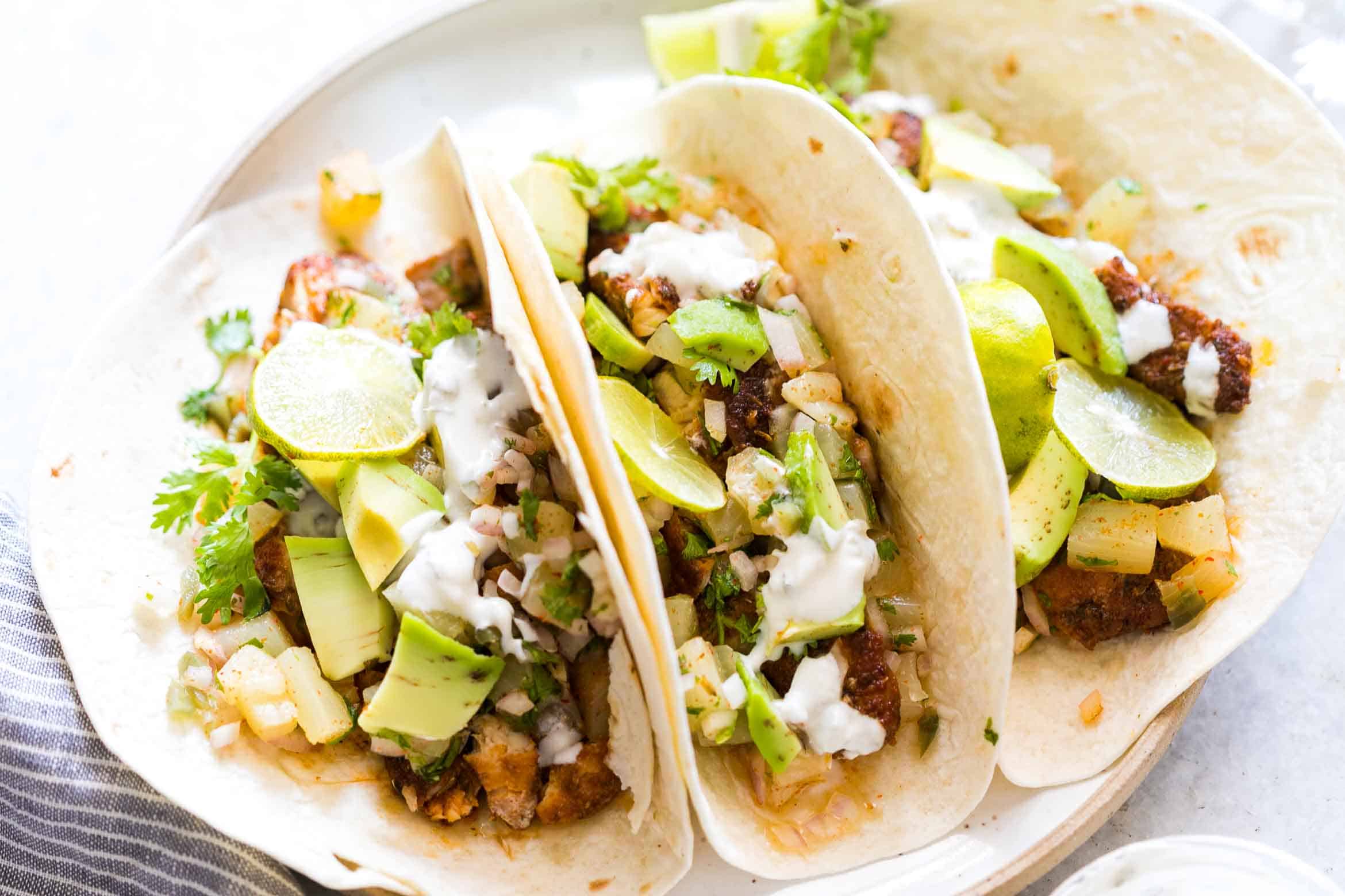 These tilapia fish tacos with pineapple salsa is just what you need when you want healthy dinner in 30 minutes! Topped with avocados and drizzled with a delicious yogurt and sour cream sauce, Taco Tuesday just became more delicious!